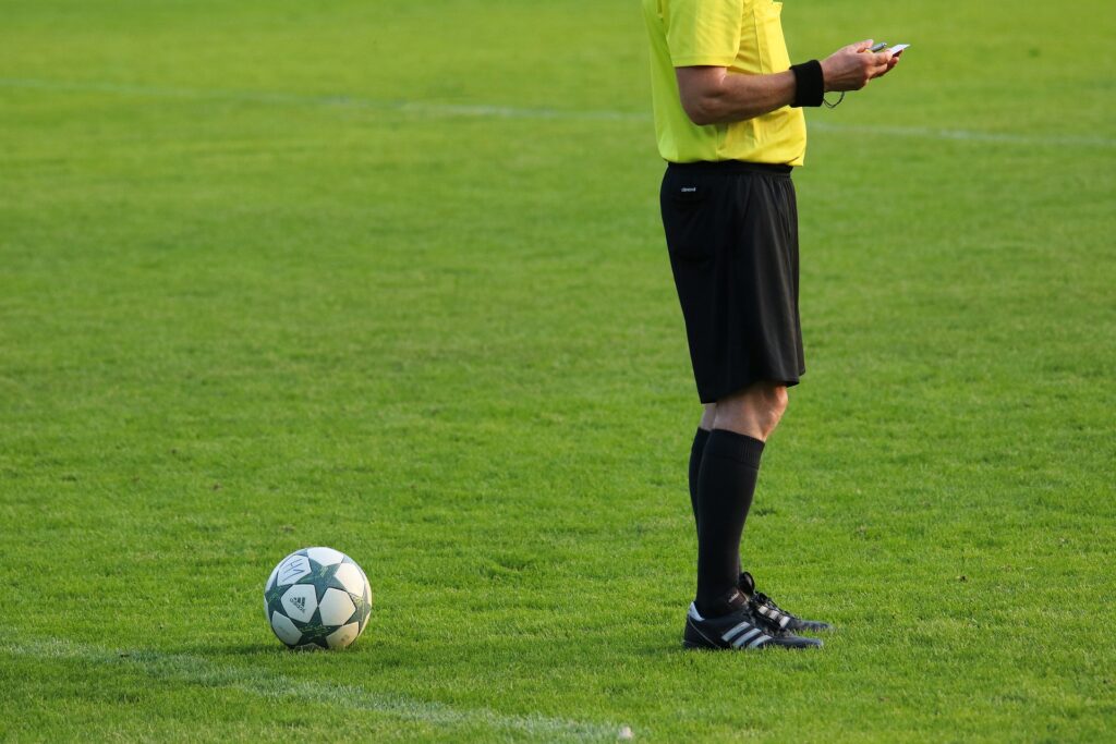 Youth soccer referee checking his match notes.
